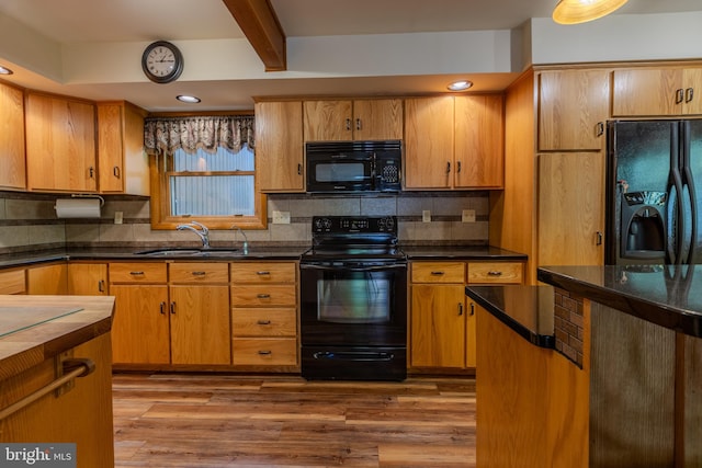 kitchen featuring light hardwood / wood-style floors, tasteful backsplash, black appliances, and sink