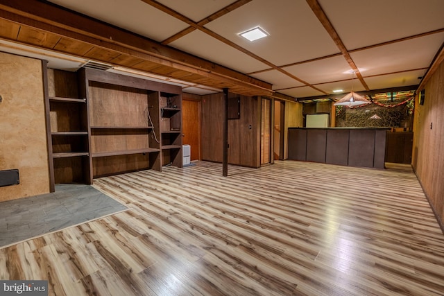 basement featuring light hardwood / wood-style flooring and wood walls