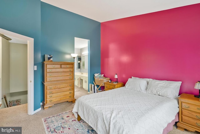 bedroom featuring ensuite bathroom and carpet