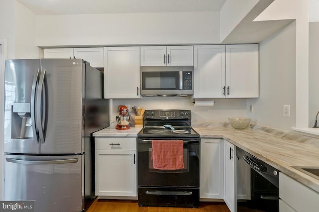 kitchen with white cabinetry and black appliances