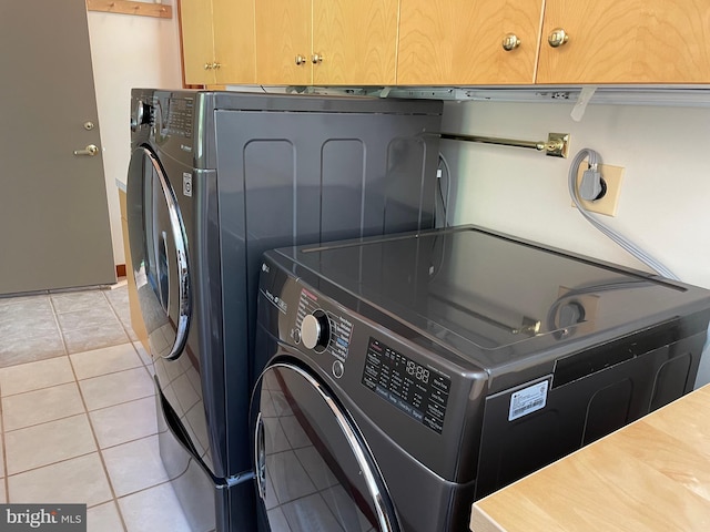 laundry area featuring cabinets and light tile patterned flooring