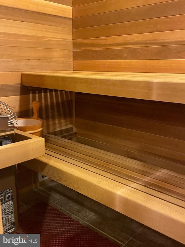 view of sauna with wood walls and tile patterned floors