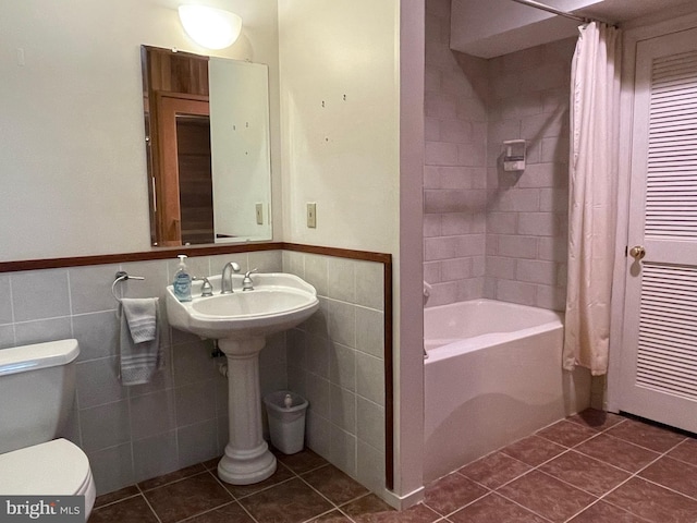 bathroom featuring shower / tub combo with curtain, tile patterned floors, tile walls, and toilet