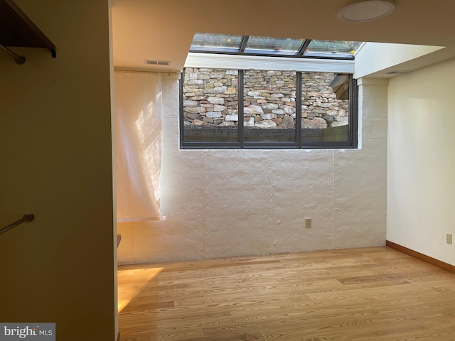 interior space featuring a skylight and hardwood / wood-style floors