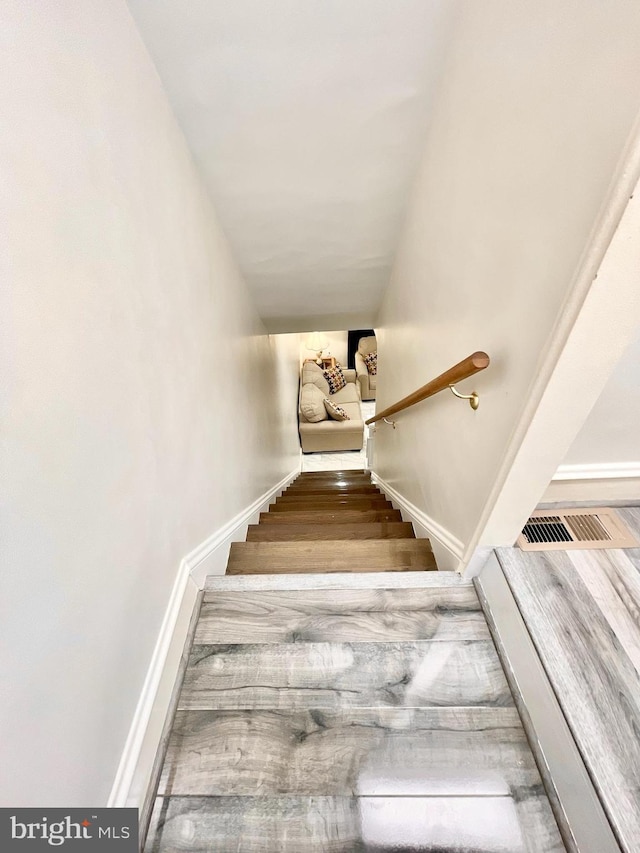 staircase featuring wood-type flooring