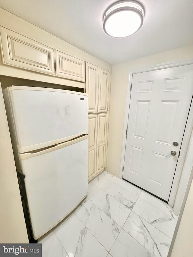 kitchen with white fridge and cream cabinetry