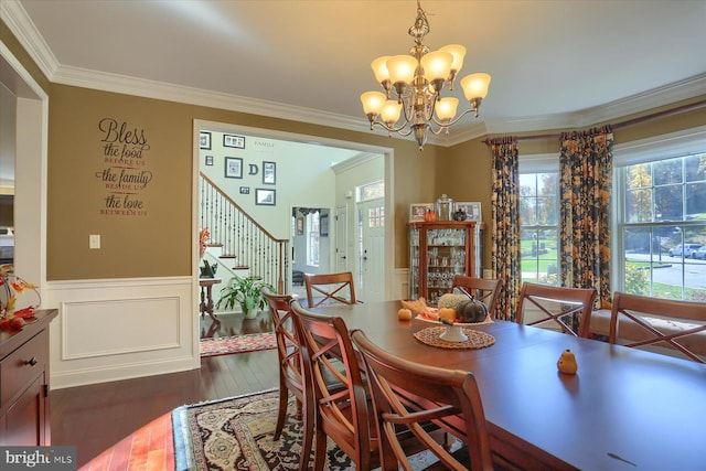 dining space featuring dark wood-style floors, a wainscoted wall, stairway, ornamental molding, and a chandelier