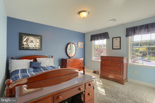 bedroom with light colored carpet, visible vents, and baseboards