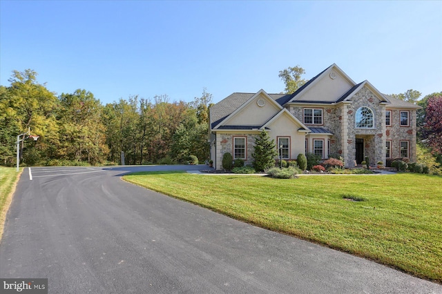 view of front of house featuring stone siding and a front lawn