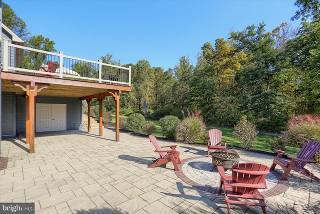 view of patio with an outdoor fire pit, stairway, and a wooden deck