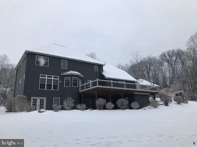 snow covered house with a deck