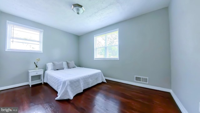 bedroom with dark wood-type flooring