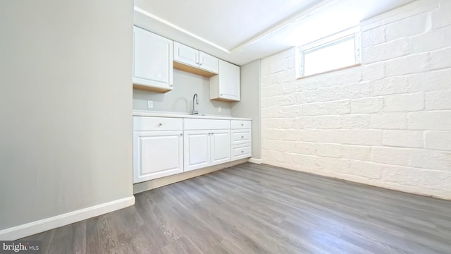 kitchen featuring sink, white cabinets, and wood-type flooring