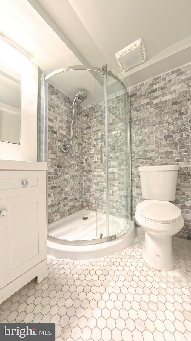 bathroom with vanity, toilet, and a shower with shower door