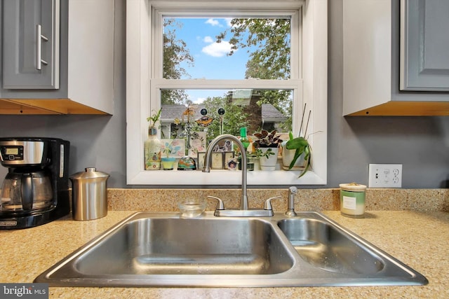 details featuring light countertops, gray cabinets, and a sink