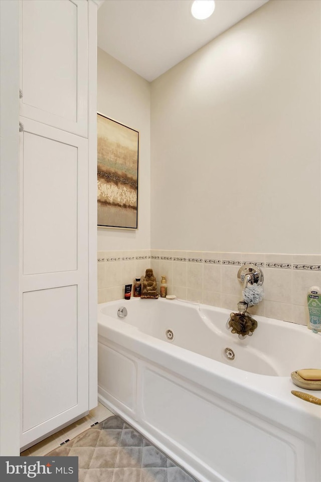 bathroom with tile patterned floors and a jetted tub