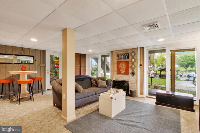living room with carpet flooring, visible vents, and a paneled ceiling
