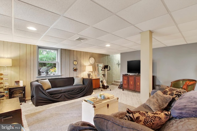 carpeted living area with recessed lighting, a wood stove, visible vents, and a drop ceiling