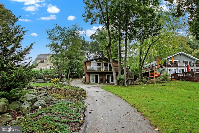 exterior space featuring a front yard and a wooden deck