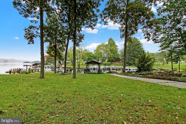 surrounding community featuring a water view, a gazebo, and a lawn