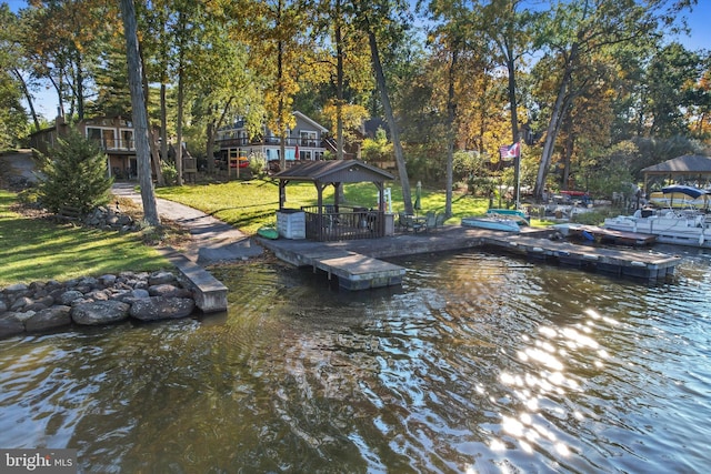 dock area featuring a water view, a gazebo, and a yard