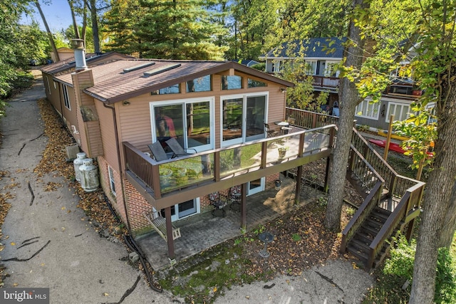 rear view of house featuring a wooden deck and stairs