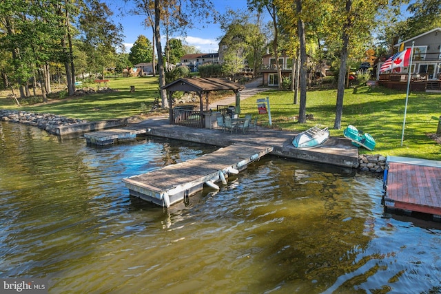 dock area featuring a gazebo, a water view, and a lawn