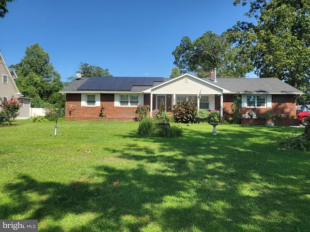 ranch-style house with a front lawn and solar panels