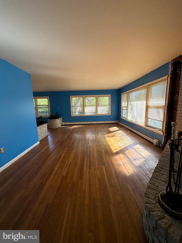 unfurnished living room with a baseboard heating unit and hardwood / wood-style flooring