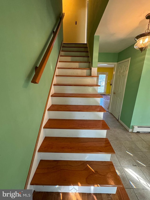 staircase with an inviting chandelier, tile patterned floors, and a baseboard radiator