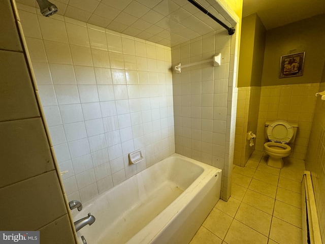 bathroom featuring toilet, tile walls, baseboard heating, tiled shower / bath, and tile patterned flooring