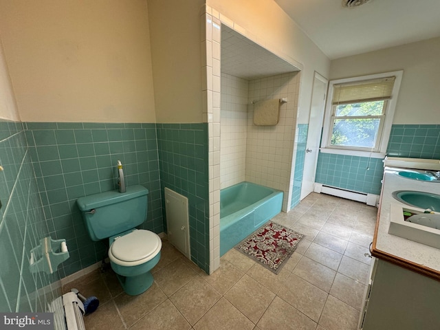 bathroom with a baseboard radiator, vanity, toilet, tile walls, and a bathtub