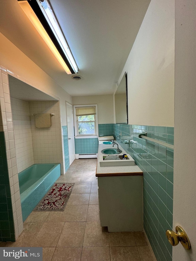 bathroom with a baseboard radiator, tile patterned floors, tile walls, a bathing tub, and vanity