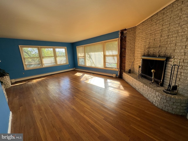 unfurnished living room with hardwood / wood-style floors, a baseboard heating unit, and a brick fireplace