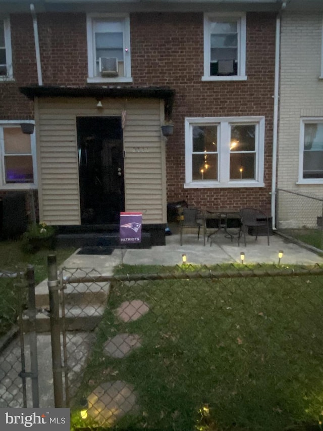 rear view of property with cooling unit, a patio area, and a yard