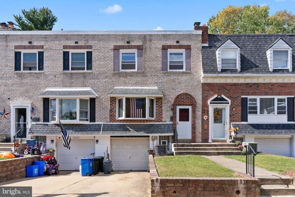 view of property with a garage and central air condition unit