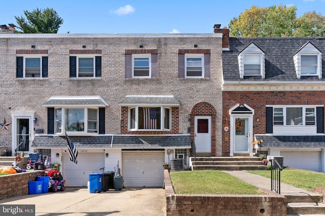 view of property with a garage and central air condition unit