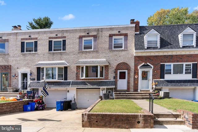 view of property with central AC unit and a garage