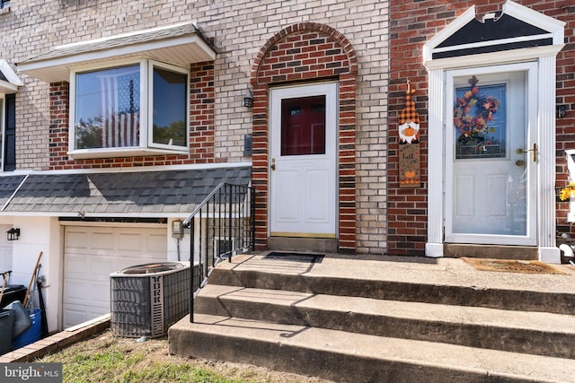 entrance to property featuring a garage and central AC unit