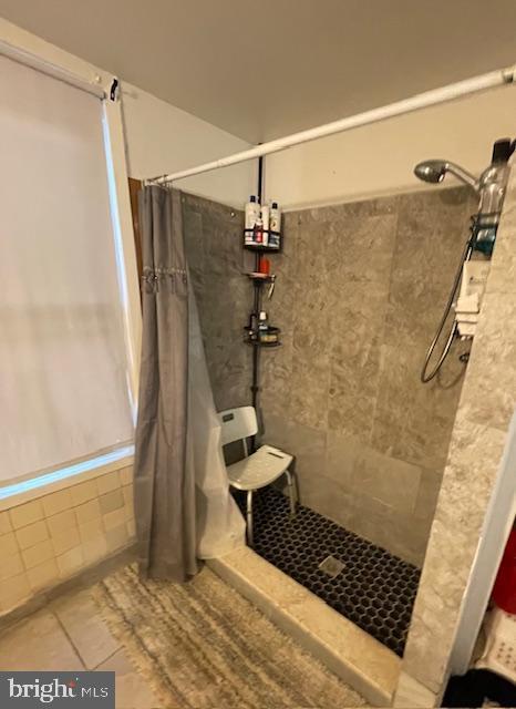 bathroom featuring tiled shower and tile patterned floors