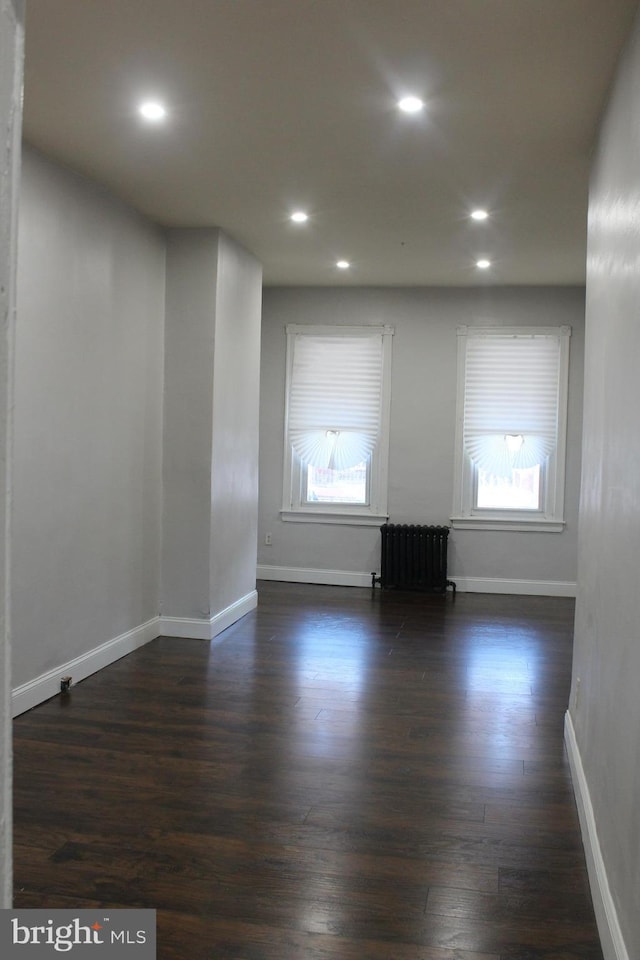 unfurnished living room featuring radiator and dark hardwood / wood-style floors