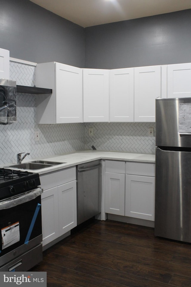 kitchen with white cabinetry, appliances with stainless steel finishes, and dark wood-type flooring