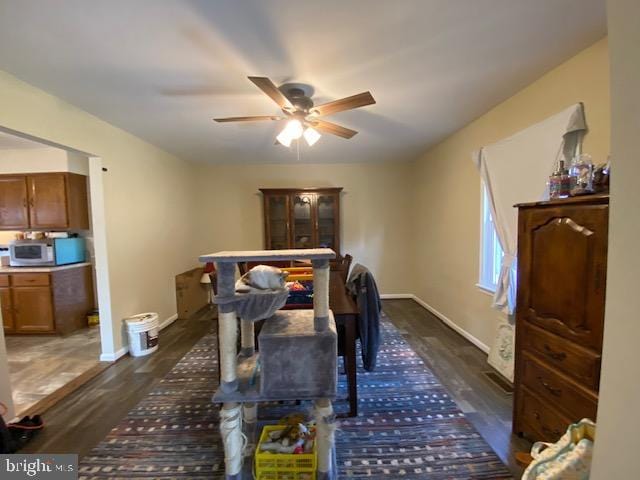 dining room with ceiling fan and dark hardwood / wood-style flooring