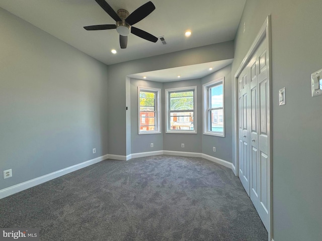 carpeted spare room with ceiling fan