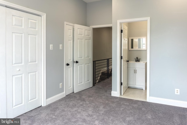 unfurnished bedroom with sink, light colored carpet, and ensuite bathroom