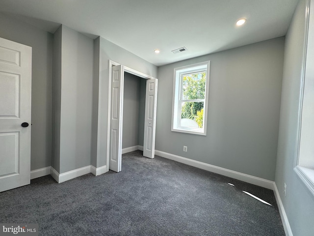 unfurnished bedroom featuring dark carpet