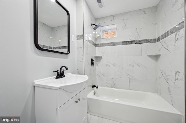 bathroom with tiled shower / bath combo and vanity