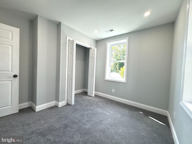 unfurnished bedroom featuring dark colored carpet