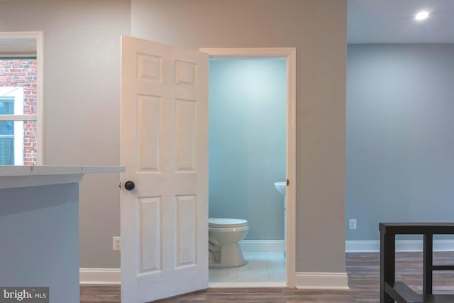 bathroom with hardwood / wood-style flooring and toilet