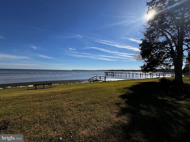 dock area featuring a lawn and a water view